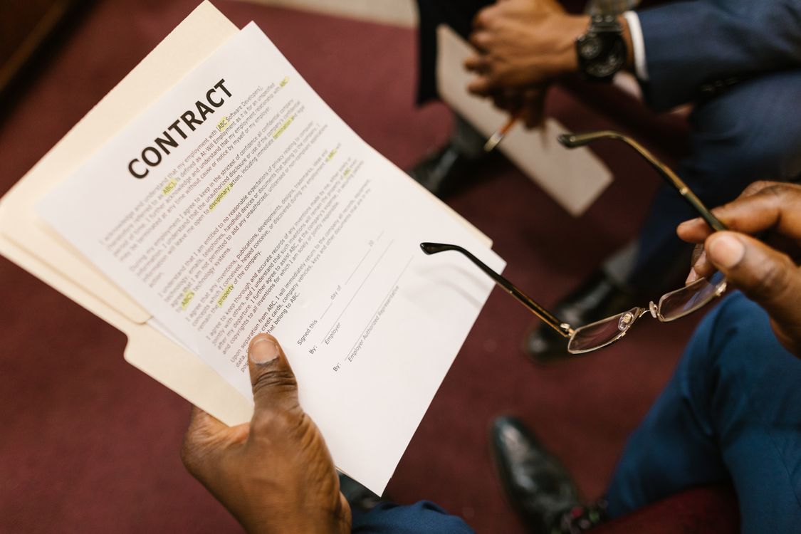 Oman final settlement checklist — close-up of a worker's hands holding an employment contract, checking it before signing
