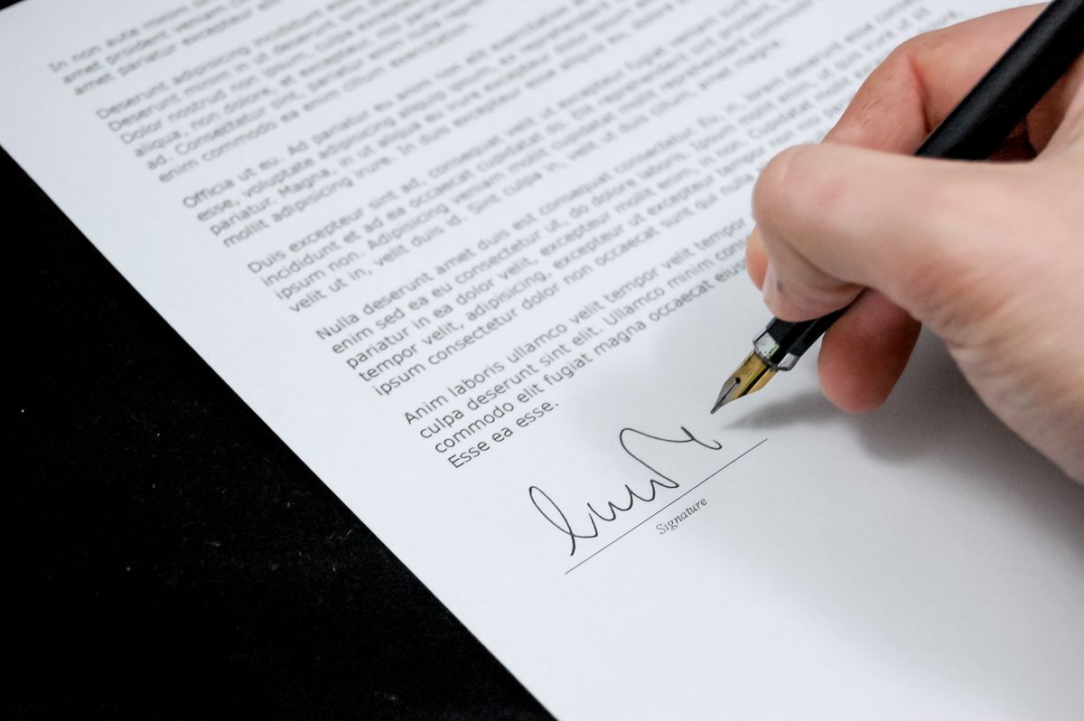 Qatar final settlement - signing final settlement document with pen
