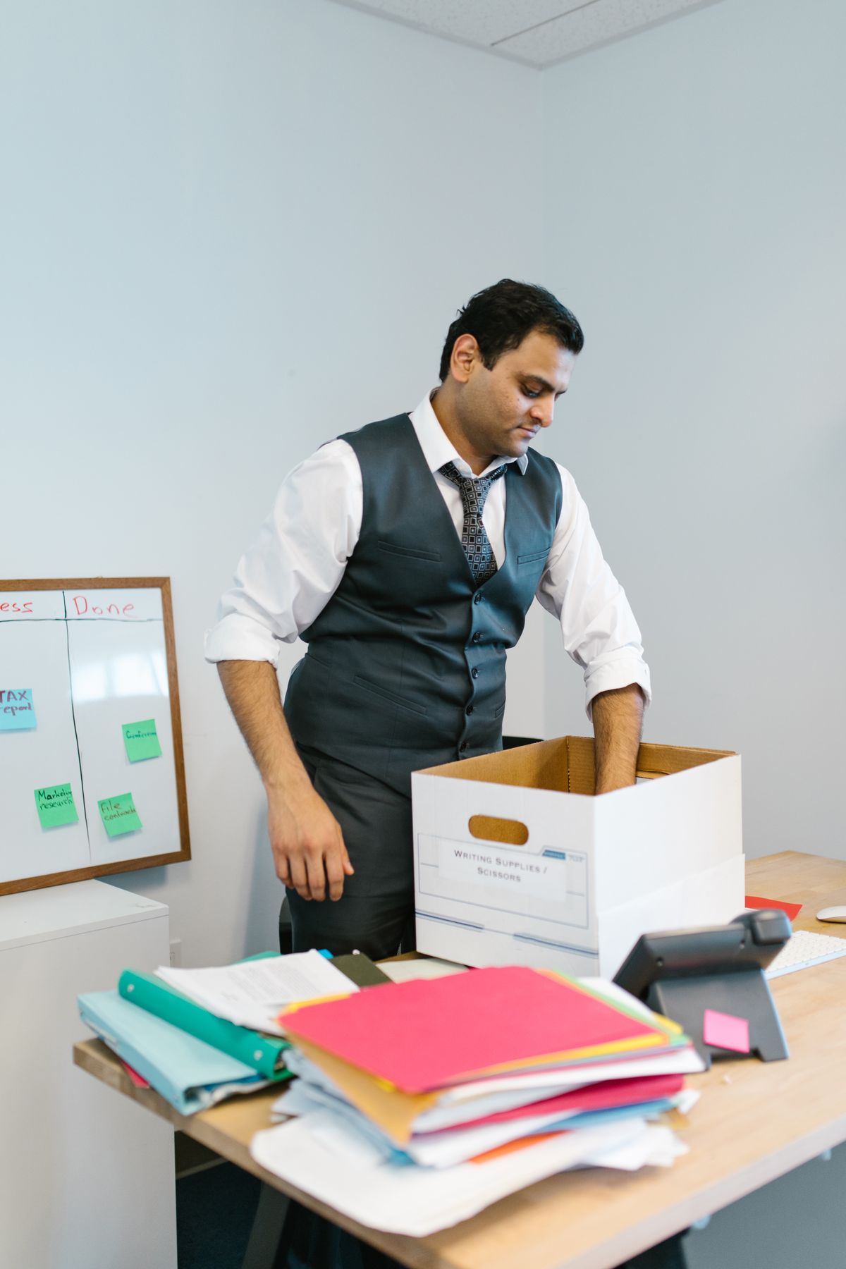 Qatar resign gratuity - businessman packing belongings into office box before leaving